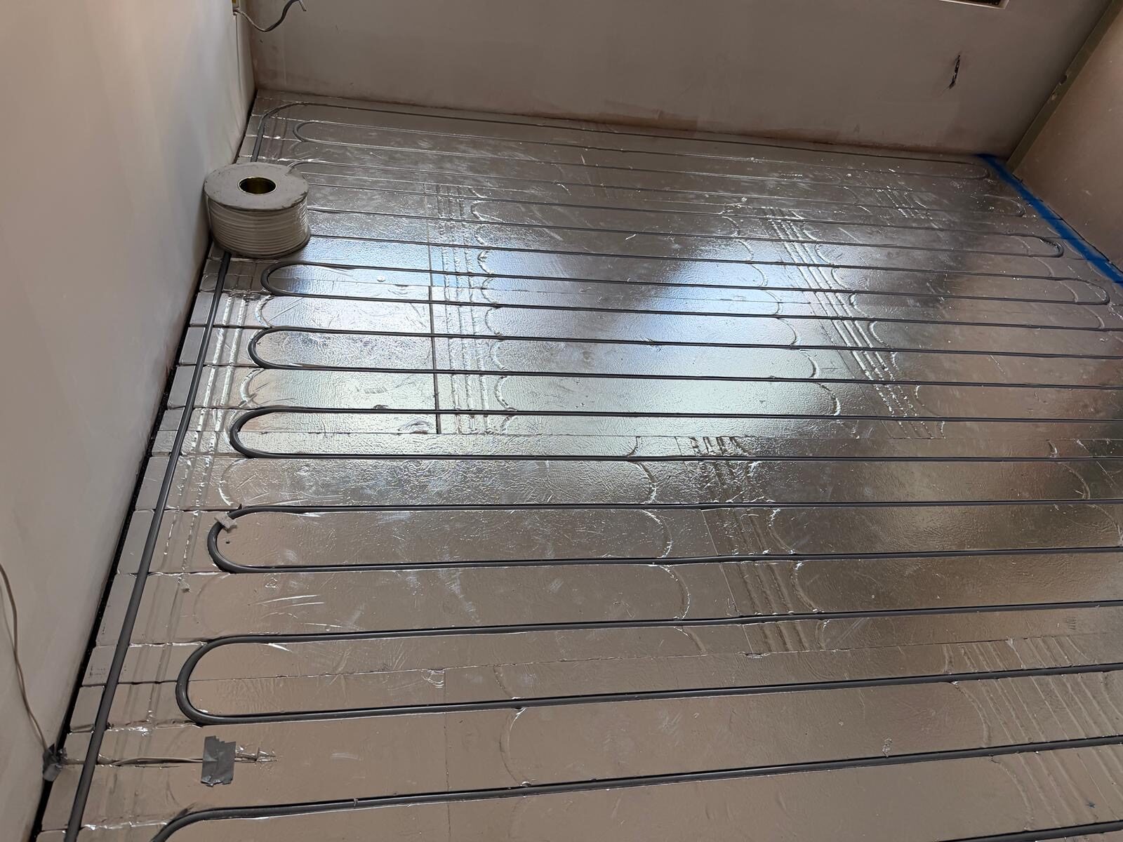 Underfloor heating laid in a bathroom on foil boards