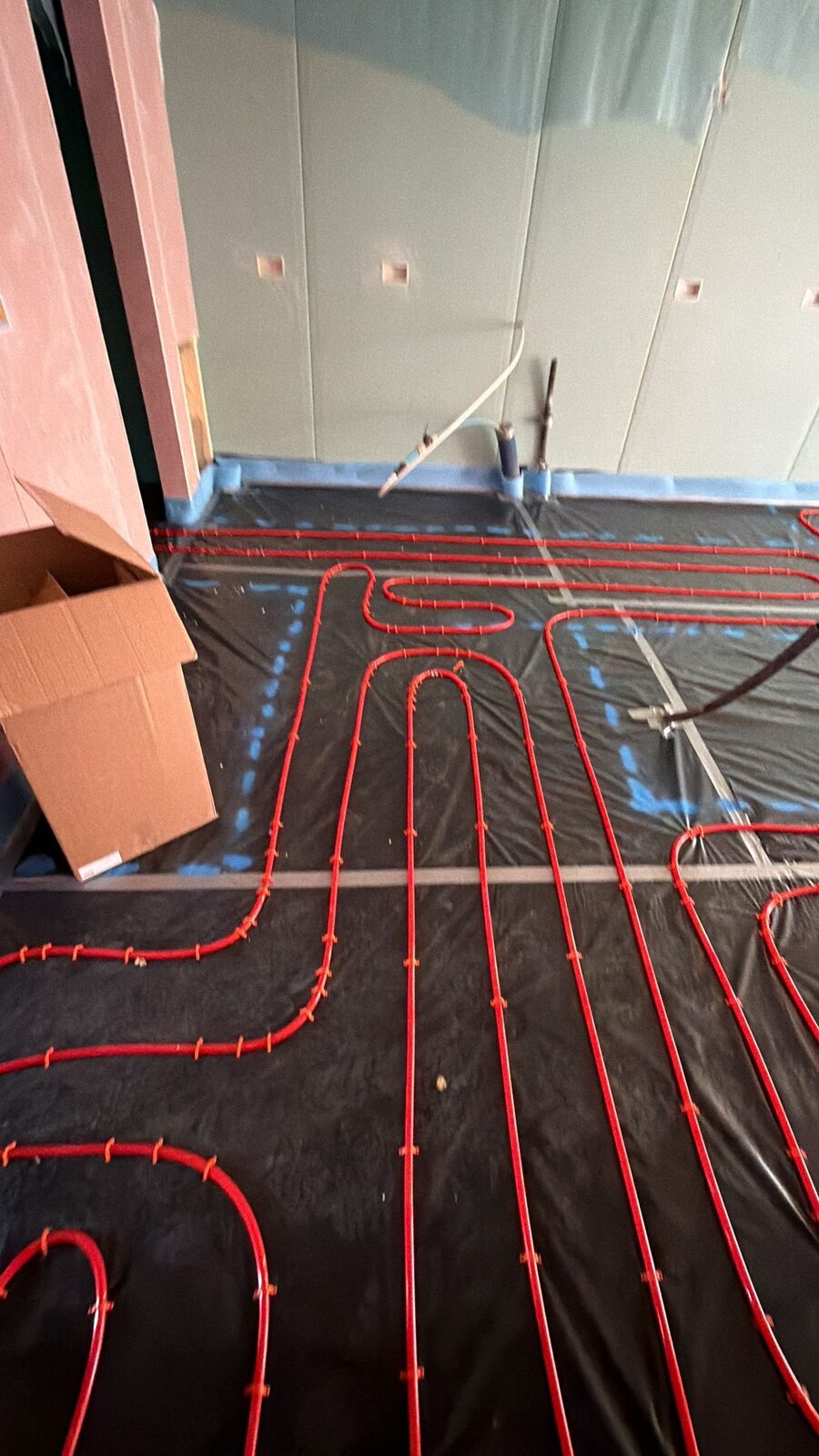 Retrofit underfloor heating pipe loops laid on insulation panels