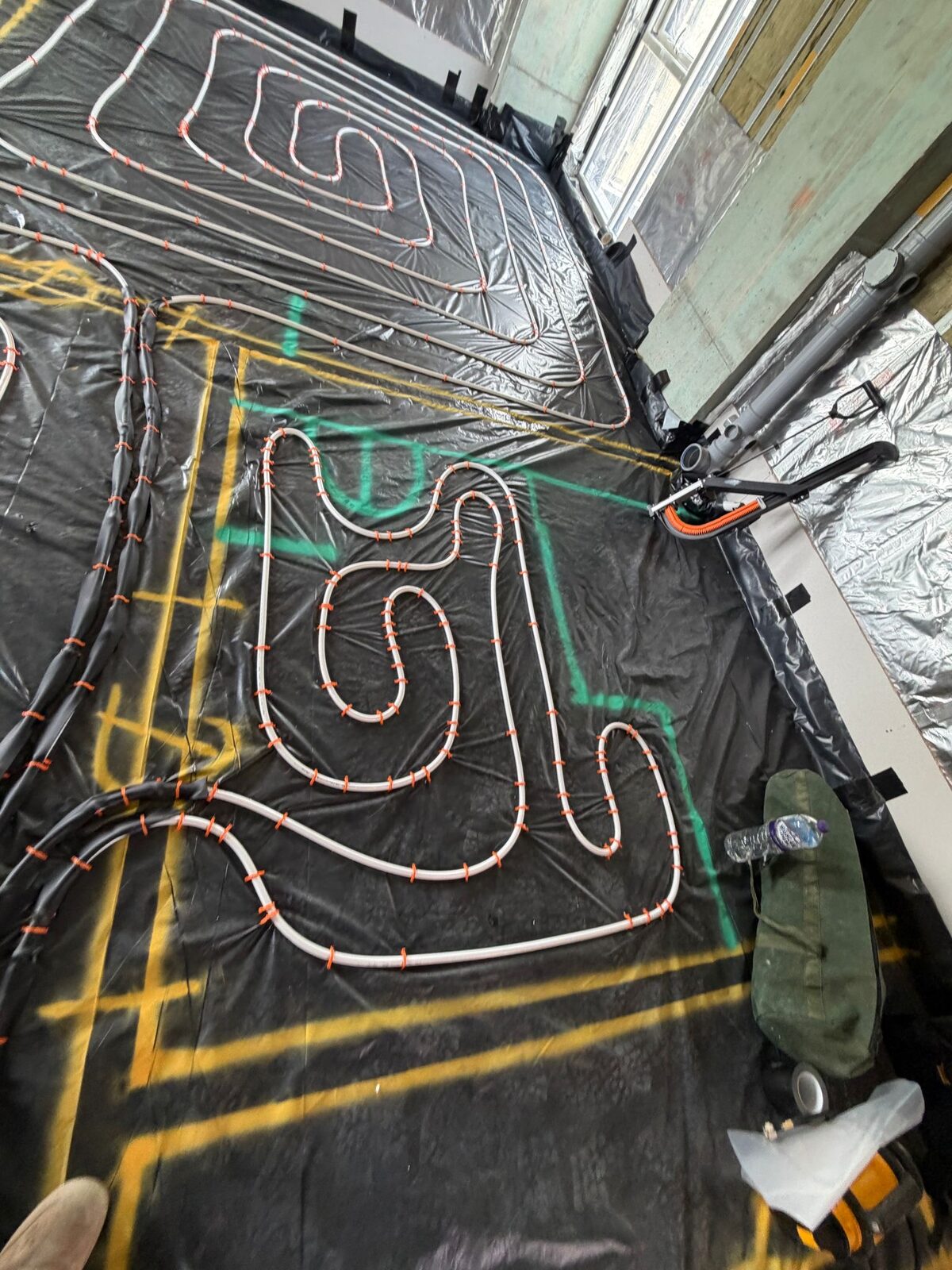 Continuous underfloor heating pipe loops laid in serpentine pattern with guide rails