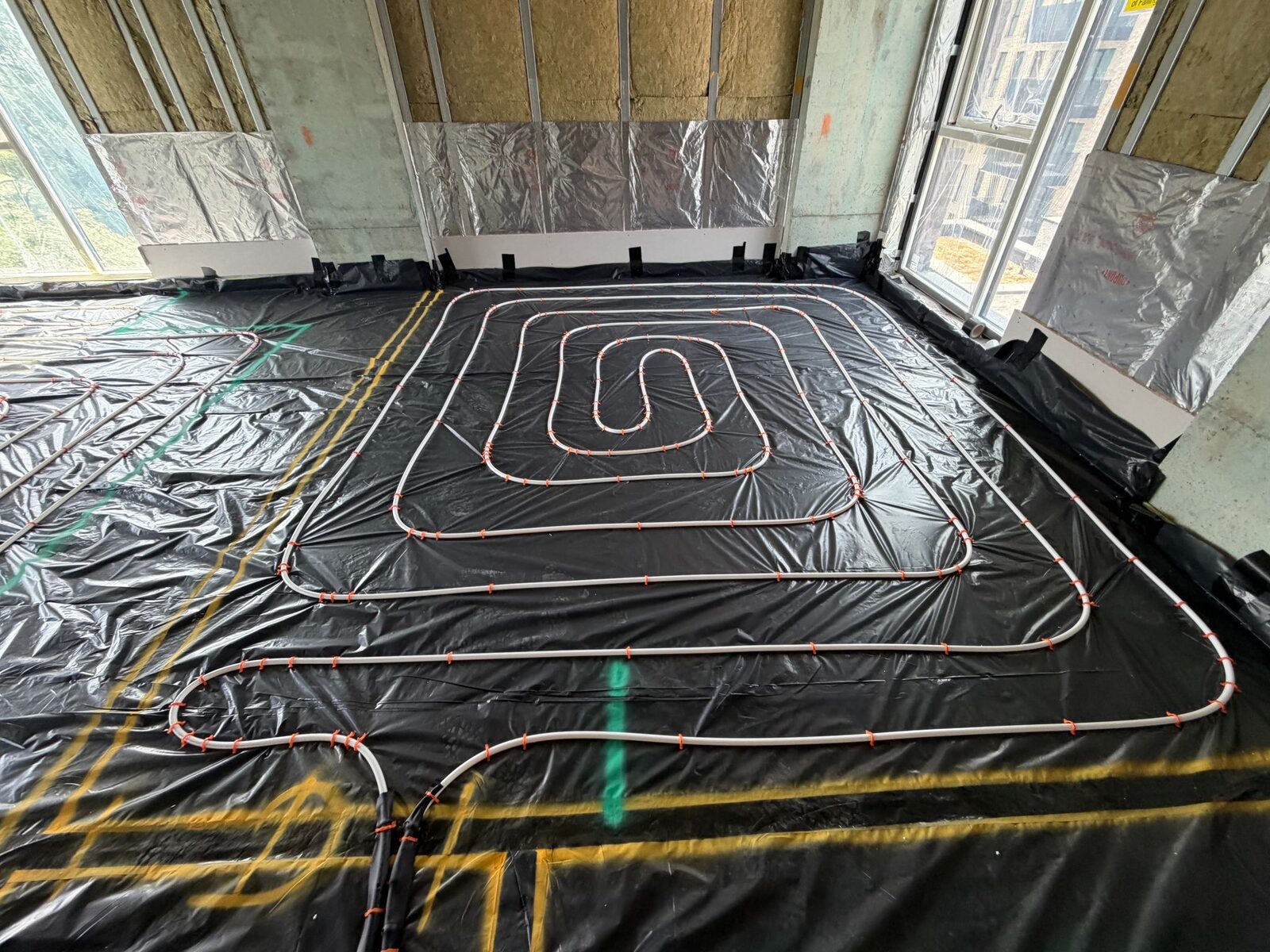 Whole-home wet underfloor heating pipe layout across a London room